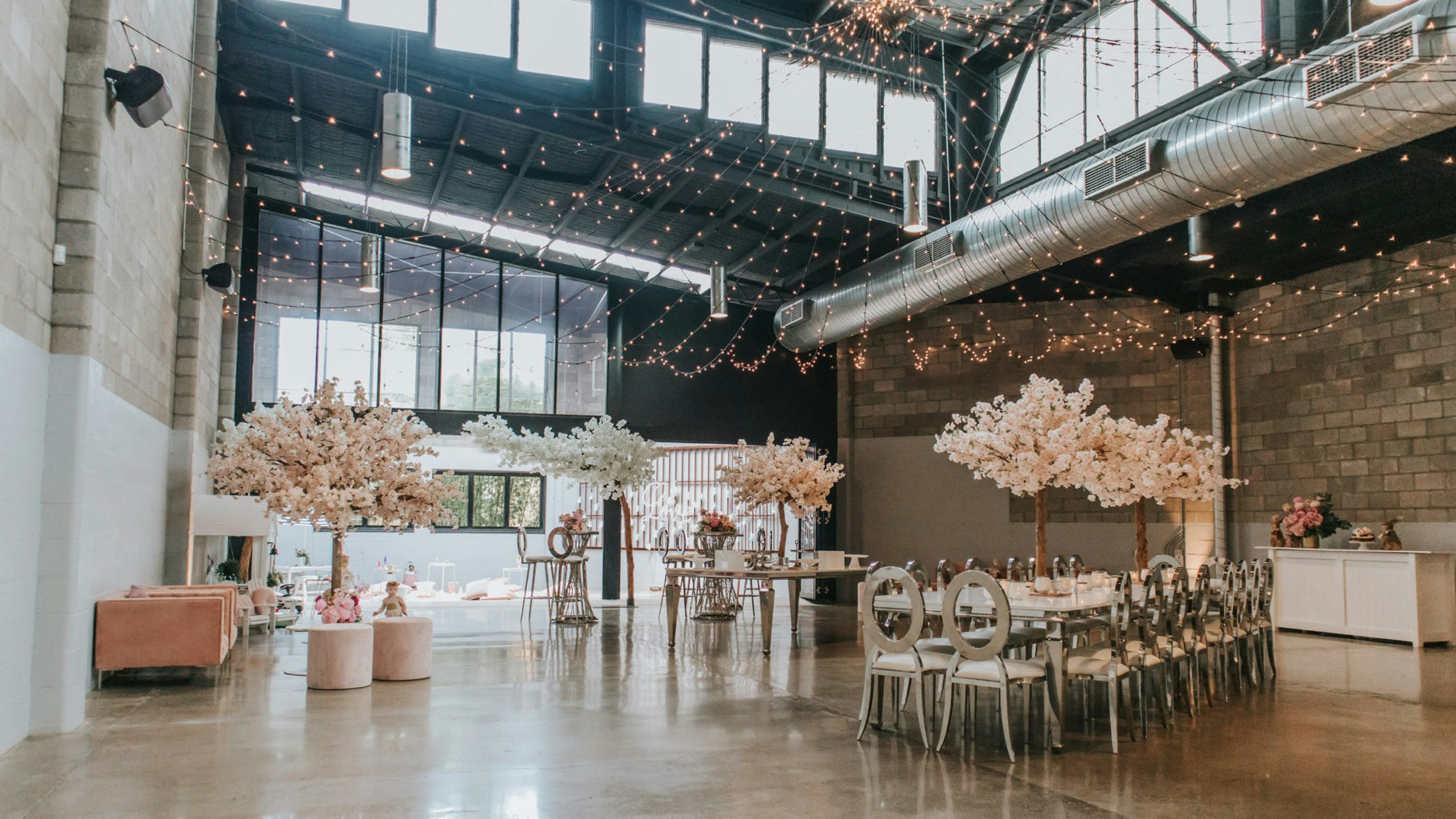 Fairy lights cast over stlyled tables in an event space.